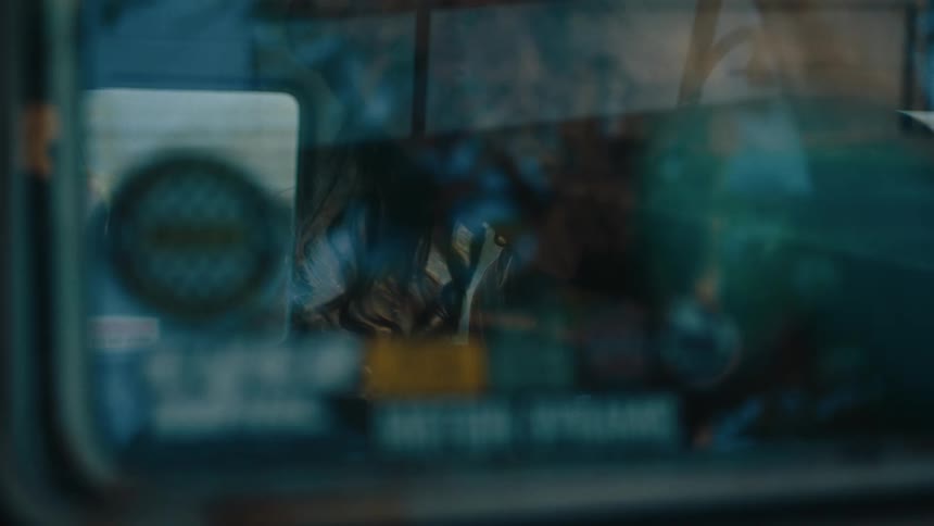 A person cleans the windows inside a vintage van using a cloth