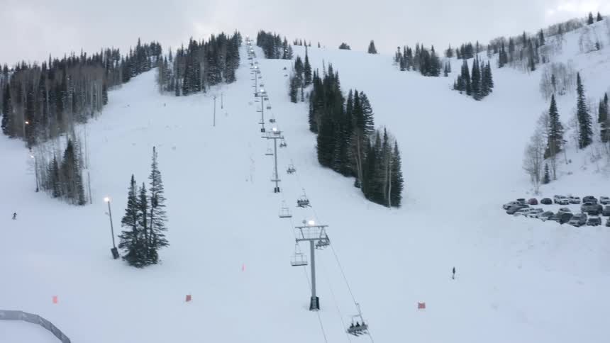 People are skiing snowboarding and riding the ski lift