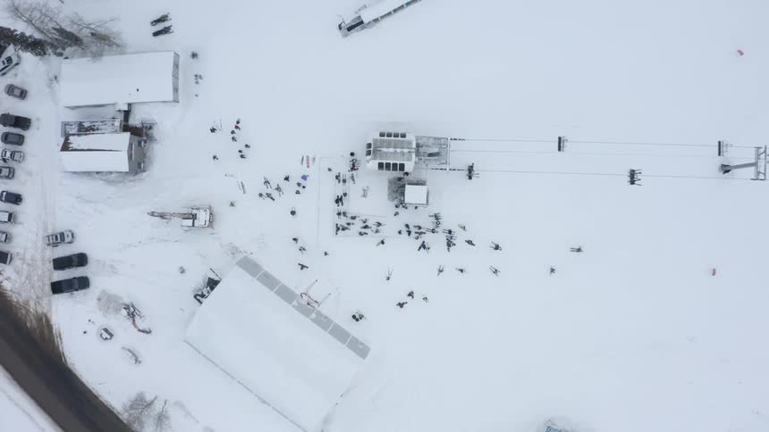 People skiing in a snow park and others on ski lifts