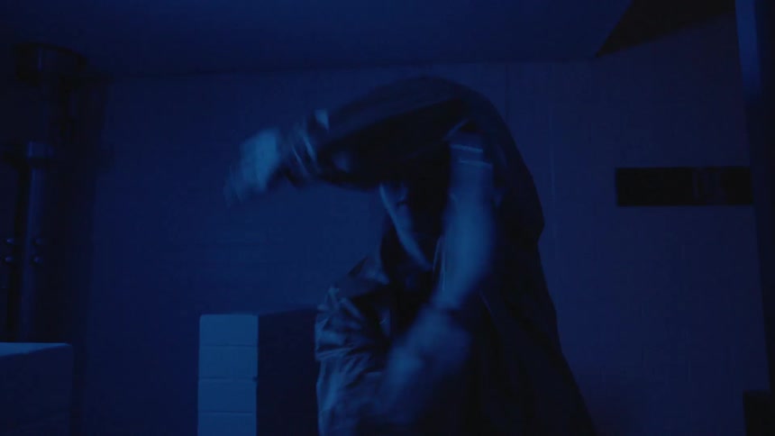 Woman dances in the dark in flashing blue light
