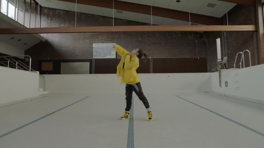 Woman dances interpratively in an indoors empty pool