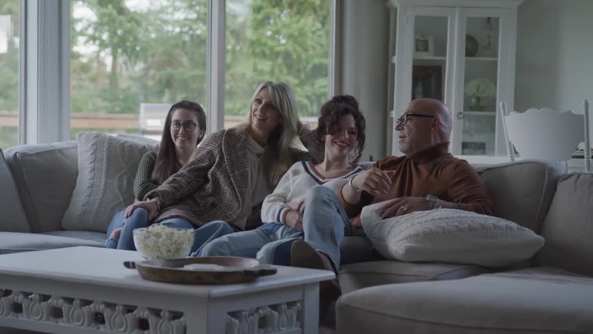 Family gathering together on the living room couch
