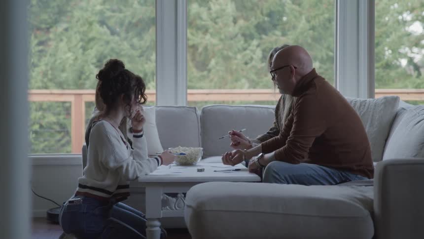 Family in living room playing game on top of a table with popcorn