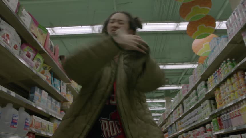 Woman dances in the aisle of a grocery store