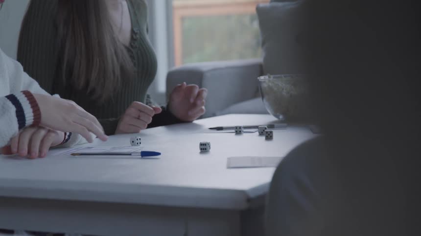 A girl throws the dice while playing a game