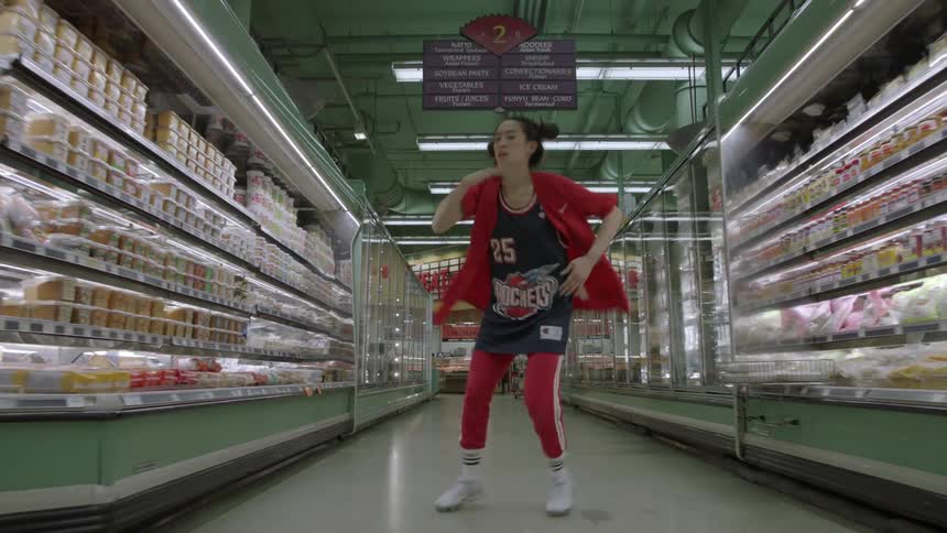 Woman dances in the aisle of a grocery store