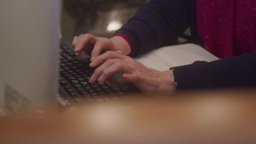 Pair of hands watching documents being injected into a computer