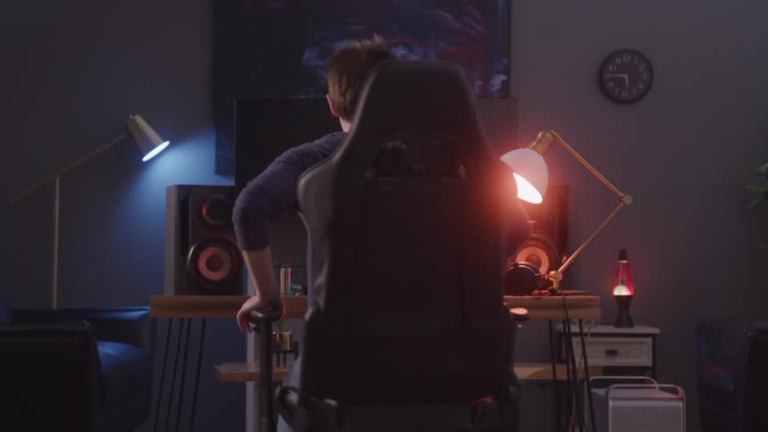 A footage of a boy siting and operating a computer