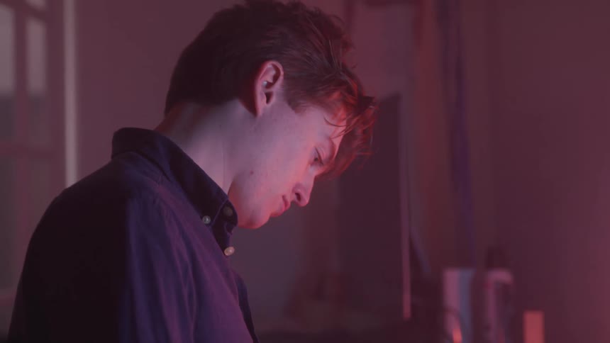Side portrait of a young man in a lowlight indoor space