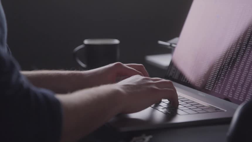 Pair of hands typing on a laptop