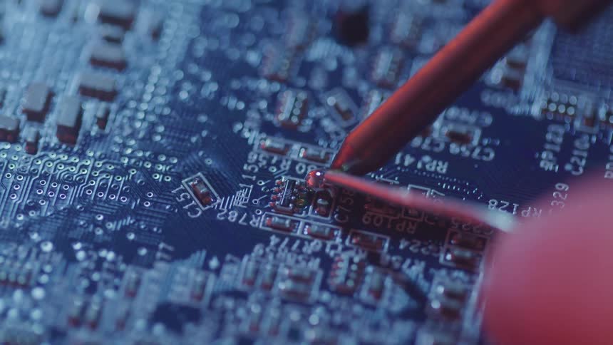 A footage of a person soldering a panel