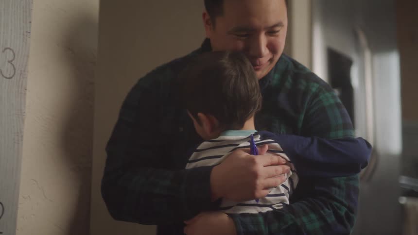 Little son hugging his father