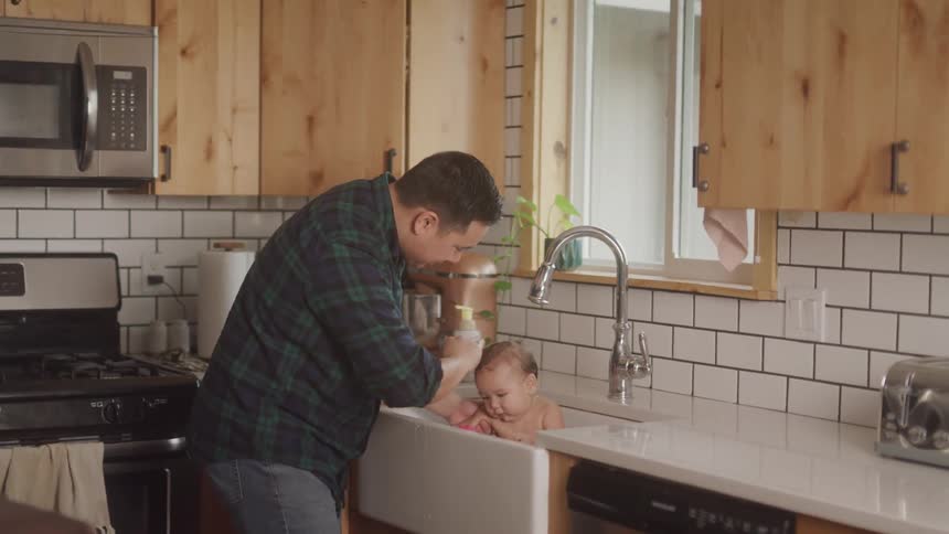 A footage of a man bathing an infant