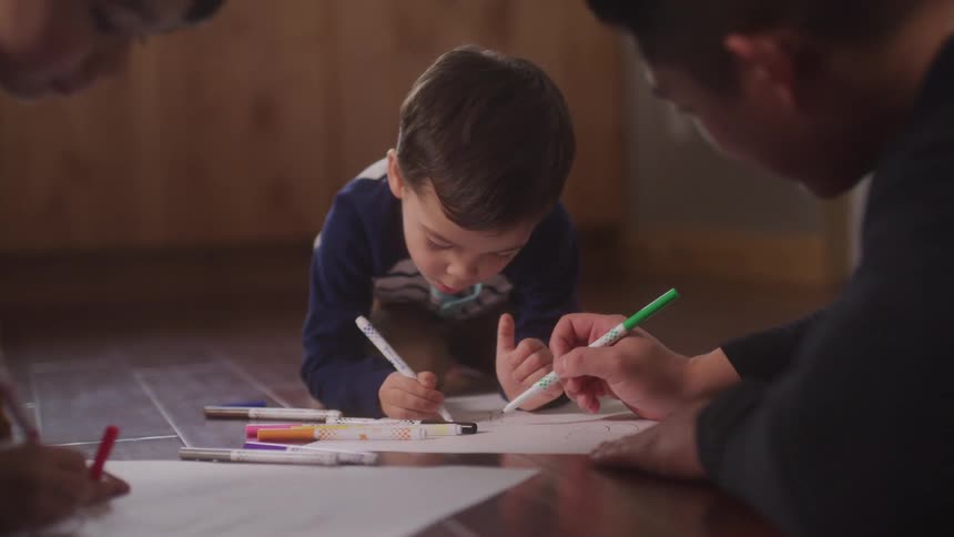 Father drawing and painting together with his two young children
