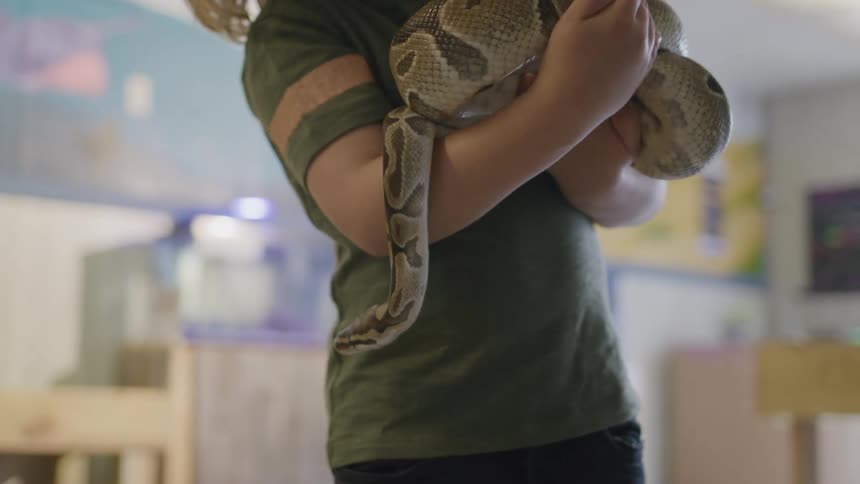 Child holding a large snake