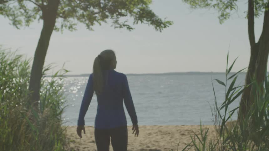 A woman walks to the beach