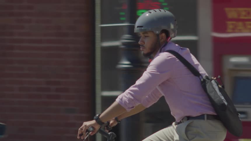 Man in helmet riding bike through city