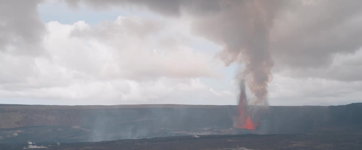 Natural landscape of lava and erupting volcano with thick smoke
