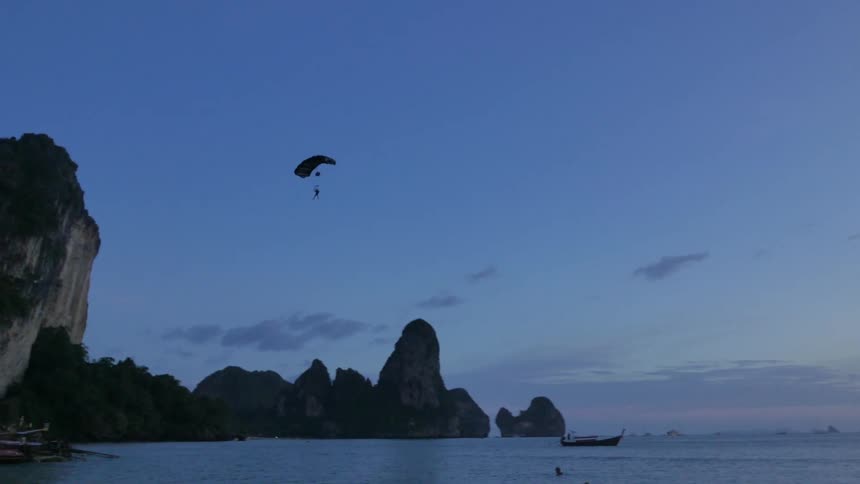 Person parachuting over a body of water