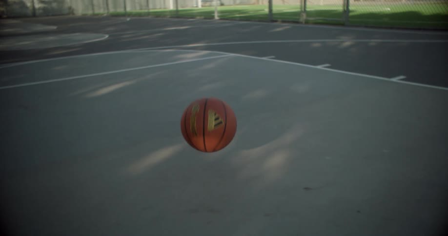 The basketball bounces and rolls on the court