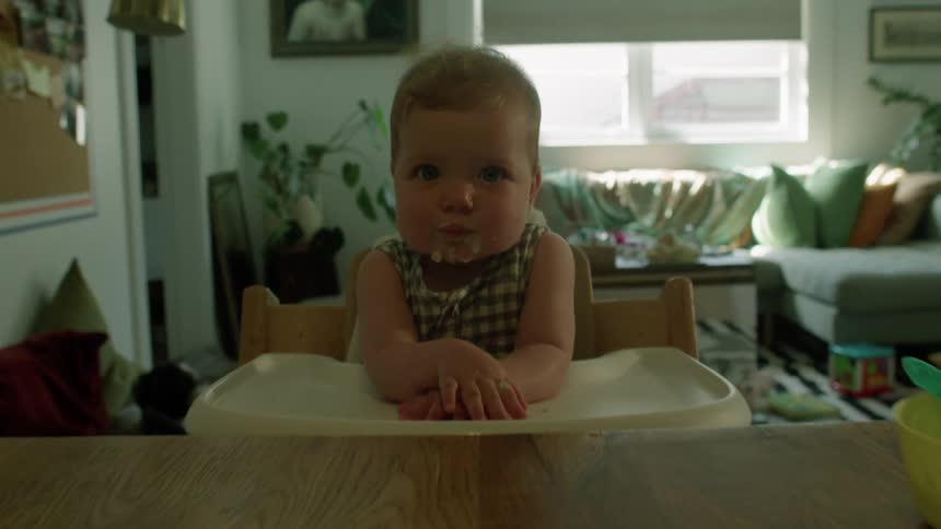 A messy baby has food all over her face