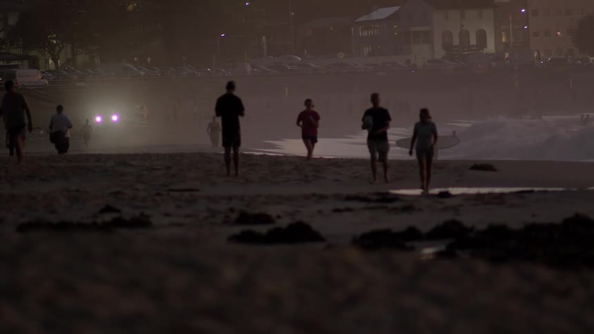 The beach is full of people on a foggy night