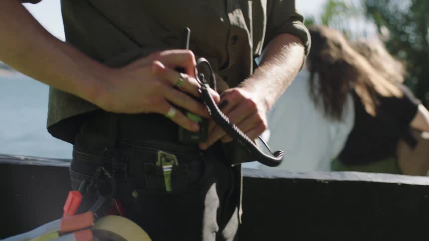Woman handing a man a piece of equipment on an outdoor filming set