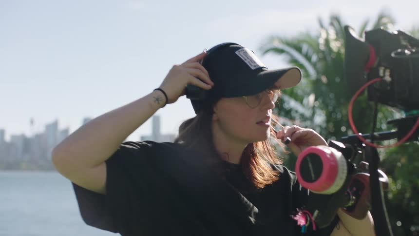 A woman is handing headphones by the camera