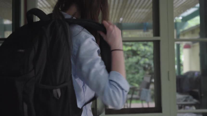 A woman ties her shoes and leaves her home