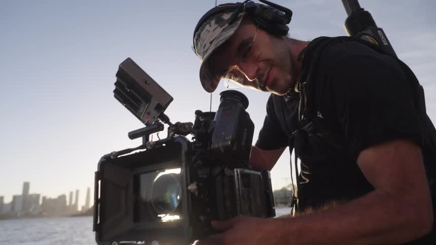 Male filmmaker using a professional video camera in an outdoor environment