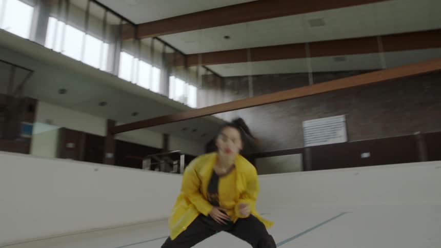 Woman dancing in an empty pool indoors
