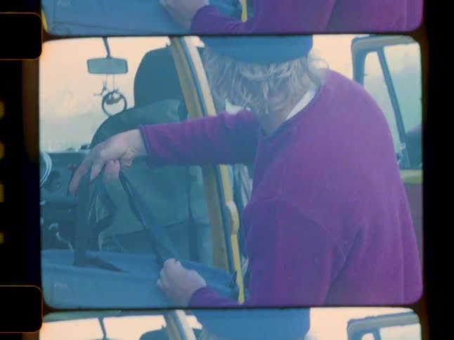 A man removes his bag from the van