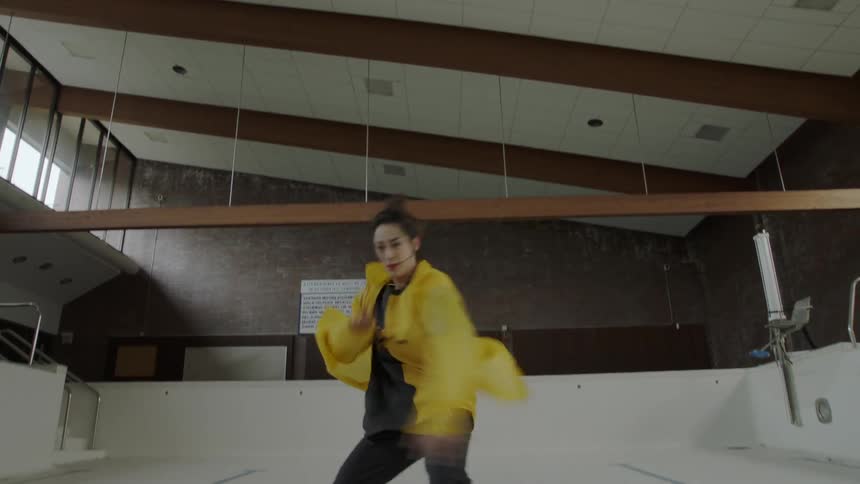 Woman dancing in an empty pool indoors