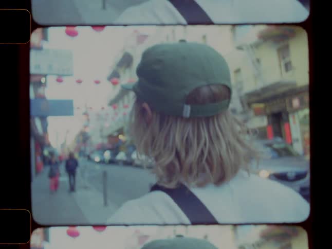 Man in cap walking on sidewalk in urban city