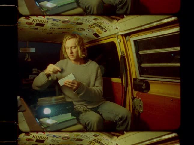 A man looks at projector slides in the van