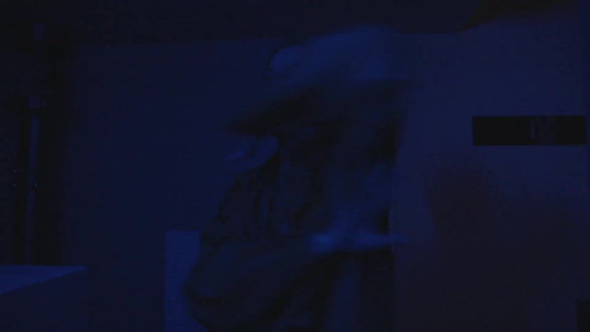 Woman dances in the dark in flashing blue light