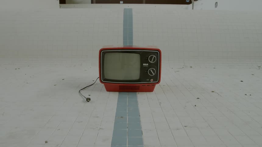 Tv in the middle of an empty pool indoors