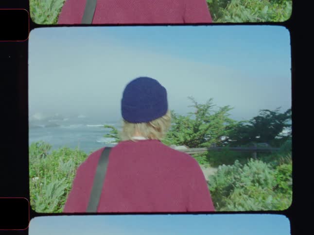 A man is walking by a cliff near the shore