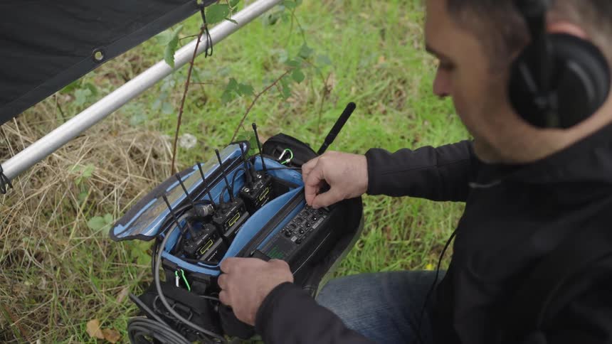 A man is adjusting the frequency on the walkie talkies