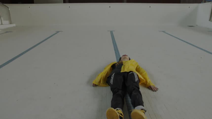 Woman dancing in an empty pool lies down