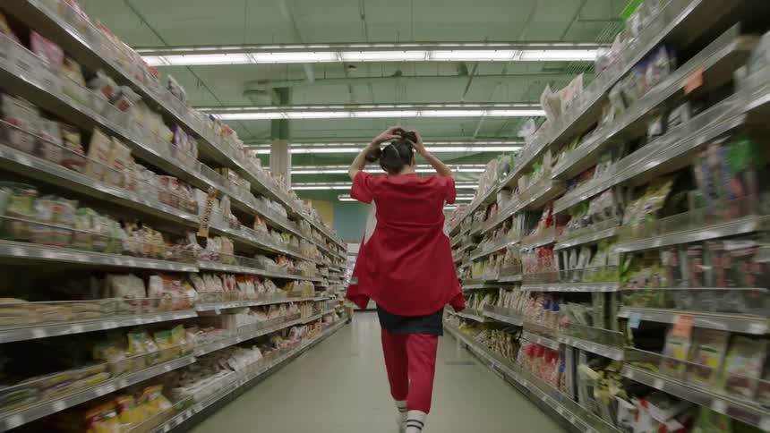 Woman walks quickly down a grocery store aisle