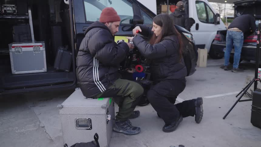 Woman and a man adjusting a professional video camera