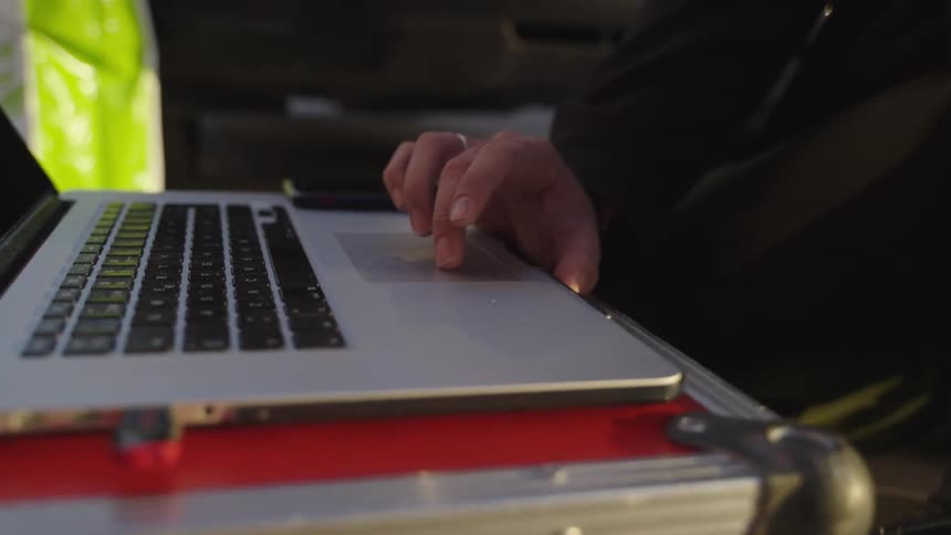 A person is using heir laptop outside