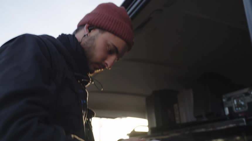 Filmmaker using masking tape in a space full of recording equipment