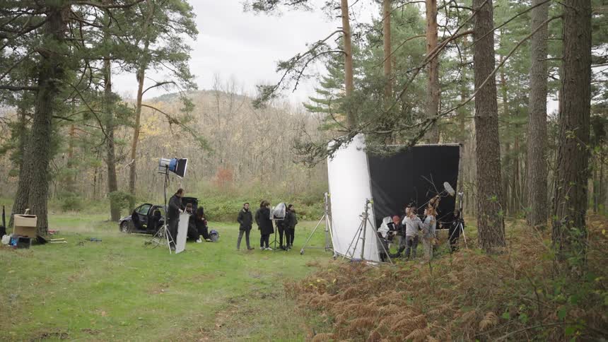A film crew are working in the forest