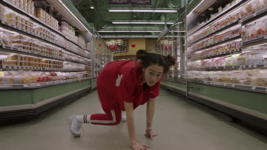 Woman dances in the aisle of a grocery store