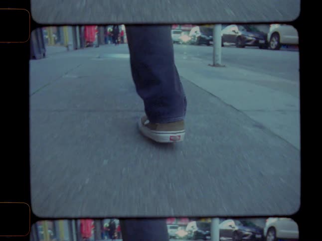 Old footage of person walking on sidewalk downtown