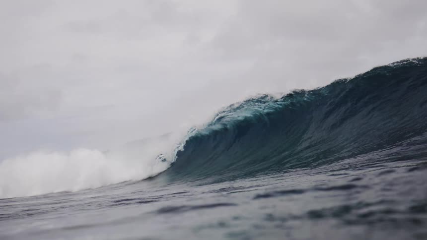 A large wave crashes in the ocean