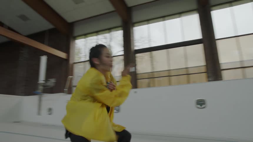 Woman dances interpretively in an indoors empty pool