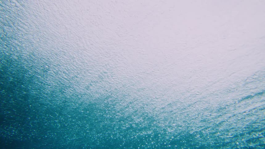 Interior view of a crystal clear sea with a wave passing and breaking